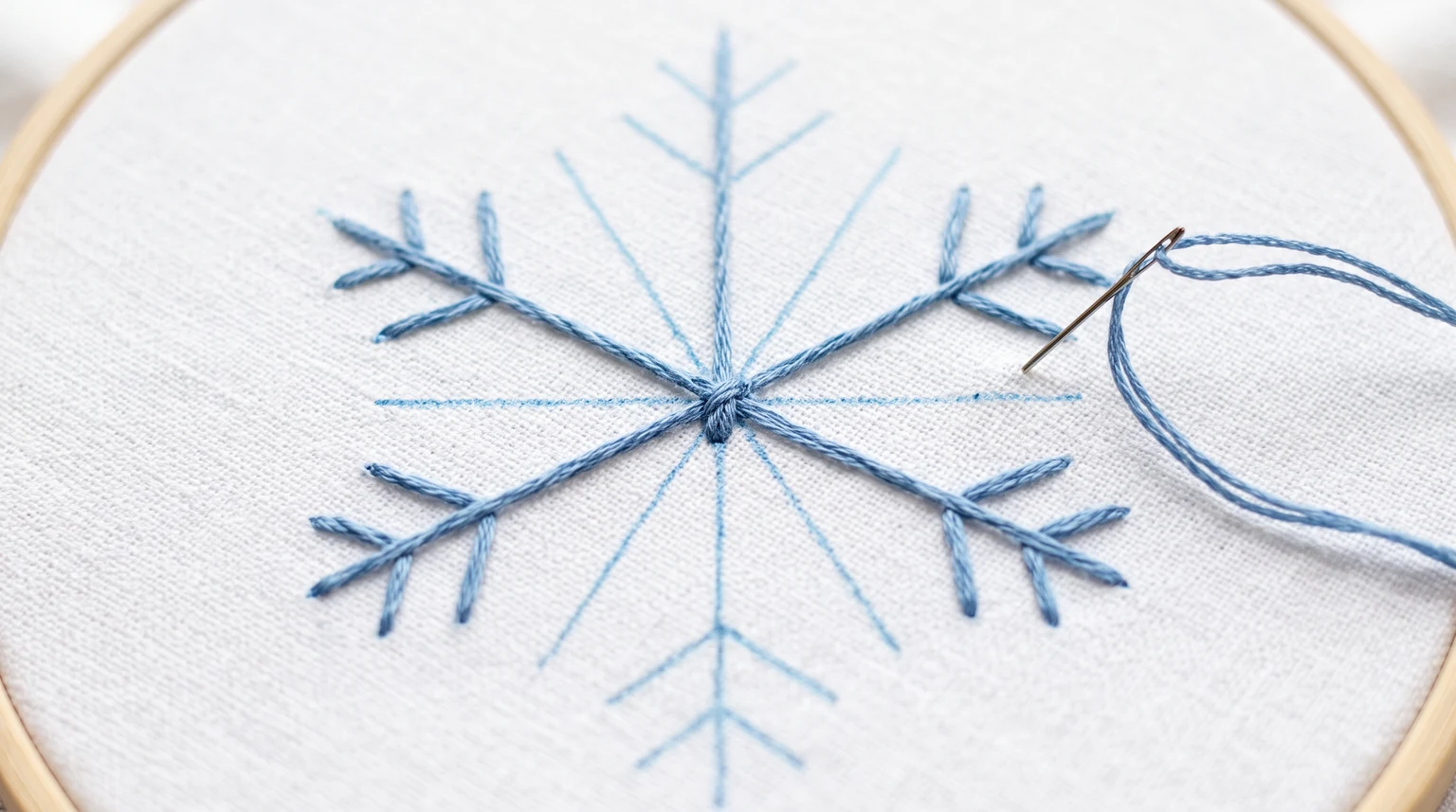 Partly stitched blue snowflake with a central crossing and marked arms and branches