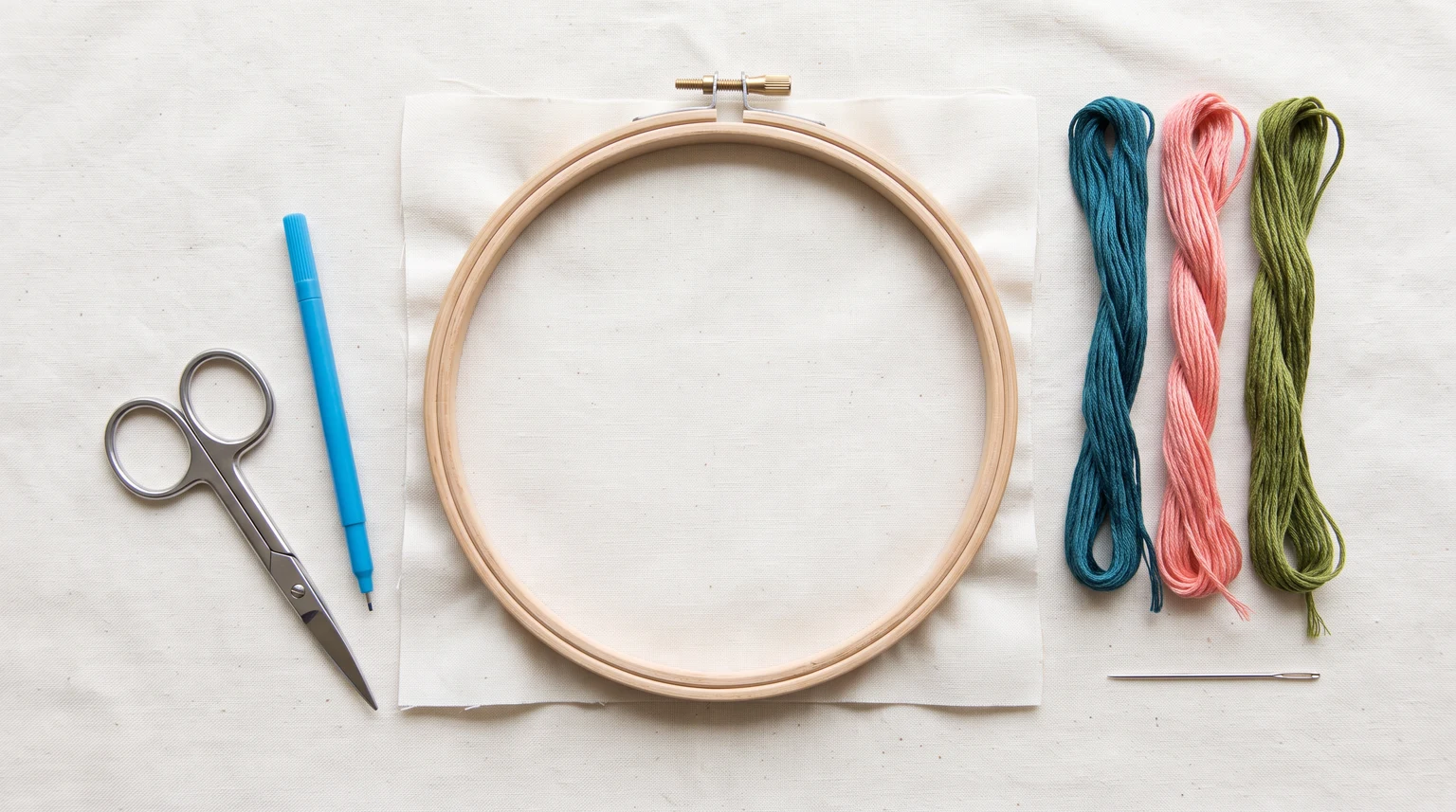 Wooden hoop, light fabric, three floss colors, scissors, marking tool and needle