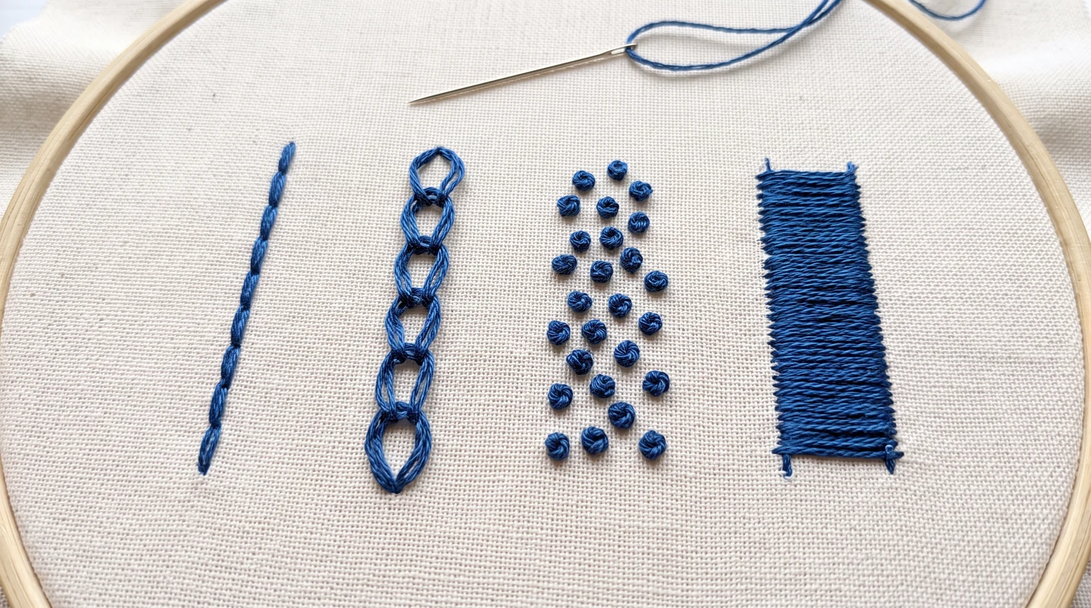 Blue embroidery sample with a segmented line, open loops, raised dots and a solid fill