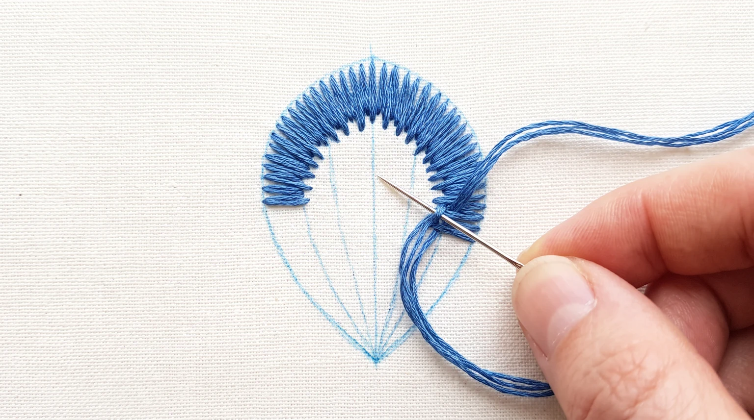 Partly filled blue petal with irregular stitch ends along the first row and direction marks below