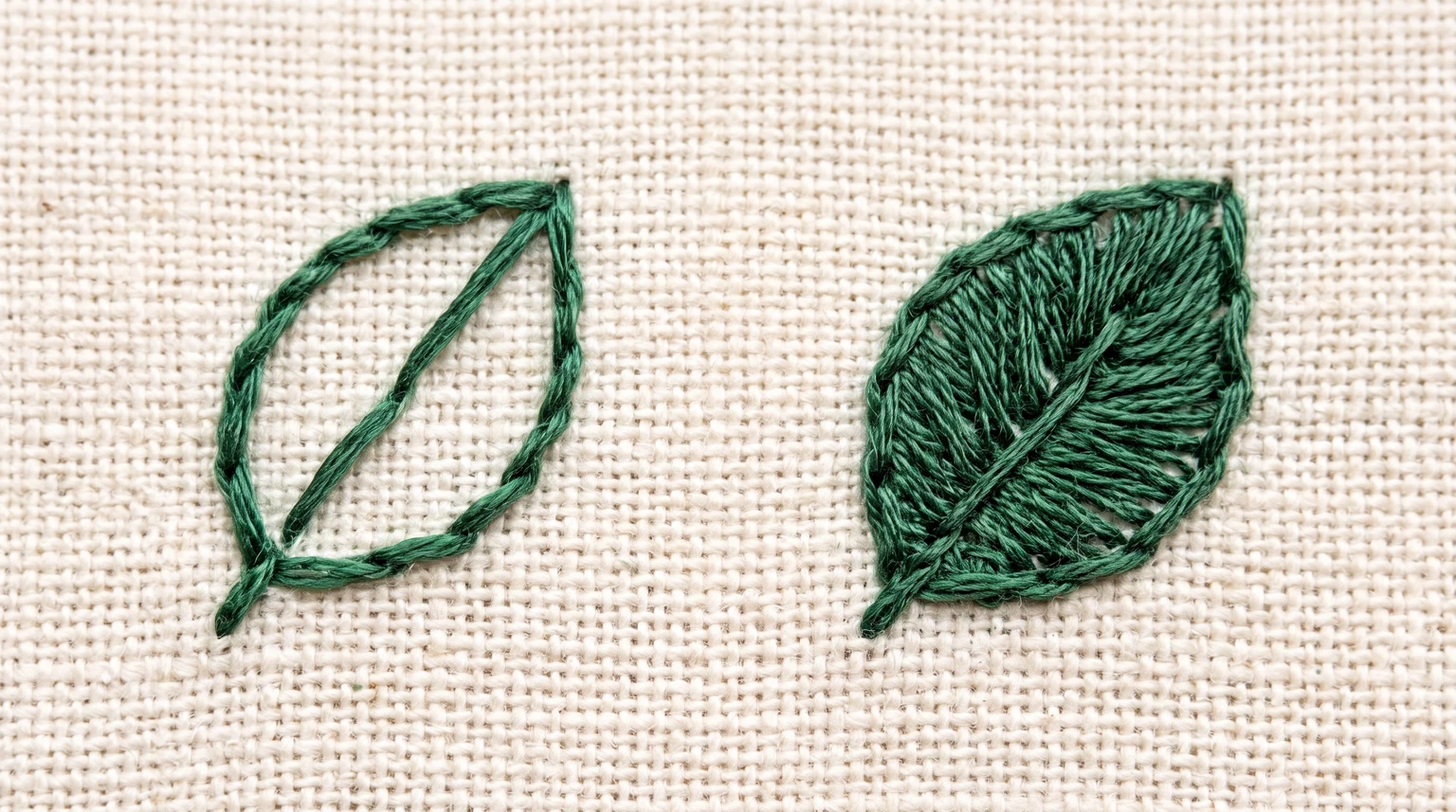 Two small green leaf motifs: an open outline with a vein and a densely stitched leaf