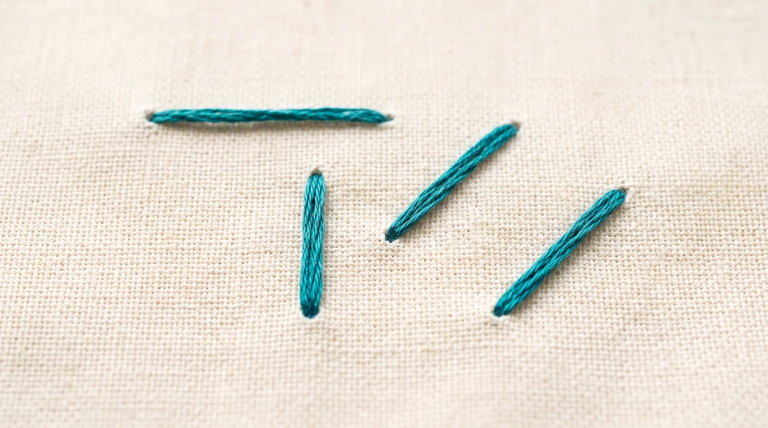 Separate teal straight stitches in horizontal, vertical and diagonal directions on light fabric